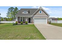 Charming home with a well-manicured lawn and a two-car garage, creating a welcoming curb appeal at 55 Bow Common Way, Cameron, NC 28326