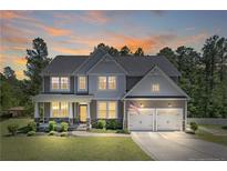 Charming two-story home featuring an attached two-car garage and a well-manicured lawn at 99 Wildlife Bridge Ct, Spring Lake, NC 28390
