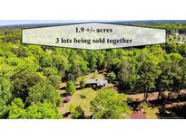 Aerial view of 1.9 acres of wooded land with a house being sold as 3 lots together at 1409 Dogwood Acres Dr, Sanford, NC 27330