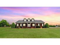Charming brick home with dormers and manicured lawn, offering a serene, country-style appeal at 2021 Rice Rd, Sanford, NC 27330