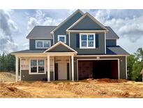 Two-story home featuring a symmetrical design, dark siding, a covered entry, and an attached two-car garage at 279 Harborwood St, Lillington, NC 27546