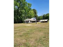 Quaint one story home with a covered porch and spacious front yard surrounded by mature trees at 3042 Overhills Rd, Bunnlevel, NC 28323
