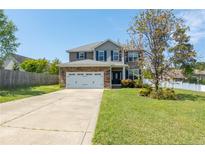Charming two-story home with a two-car garage, stone accents, and a well-manicured lawn on a sunny day at 37 Annapolis Rd, Cameron, NC 28326