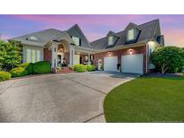Beautiful brick home with a well-manicured lawn and two-car garage and covered entry at 4114 Chancellors Ridge Way, Sanford, NC 27330