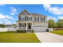 Charming two-story home with a welcoming front porch, two-car garage, and well-maintained lawn at 761 Burley Oak Dr, Cameron, NC 28326