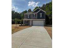 Charming two-story home featuring gray and navy blue siding with a spacious driveway at 136 Baneberry Pl, Broadway, NC 27505
