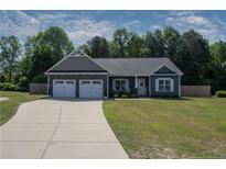 Charming single-story home with a two-car garage, beautifully manicured lawn, and inviting front porch at 199 Courtney Ln, Dunn, NC 28334