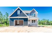 Charming two-story home with a spacious two-car garage and welcoming front porch, situated on a sunny lot at 940 Allstar Ave, Cameron, NC 28326