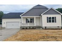 Charming home featuring a two-car garage, covered front porch, and sleek black shutters at 180 Cedar Wind Ln, Fuquay Varina, NC 27526