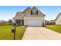 Charming two-story home featuring a well-maintained lawn and a two-car garage with a driveway at 110 Wynngate Dr, Cameron, NC 28326