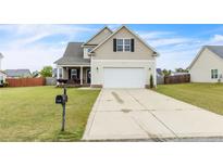 Charming home featuring a well-maintained lawn, attached garage, and inviting front porch at 110 Wynngate Dr, Cameron, NC 28326