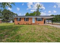 Charming single-story brick home featuring a light blue front door, dark shutters, and lush lawn at 11504 Bissette Rd, Middlesex, NC 27557