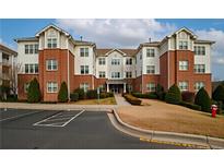 Apartment building featuring brick accents, tidy landscaping, and ample parking at 1222 Waterford Lake Dr, Cary, NC 27519