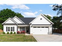 Charming single-story home with white siding, black shutters, a two-car garage, and a well-manicured front lawn at 186 N Ashe Ave, Dunn, NC 28334