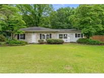 Charming one-story home featuring a well-manicured lawn and mature trees at 255 Chris Cole Rd, Sanford, NC 27332