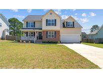 Charming two-story home featuring a welcoming porch and a well-manicured front lawn at 106 Polk St, Spring Lake, NC 28390