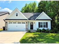 Charming single-Gathering home showcasing a two-car garage and a beautifully landscaped front yard at 121 Camille Brooks Dr, Angier, NC 27501