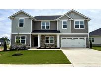Beautiful two-story home featuring a manicured lawn, attached two car garage and stone veneer accents at 122 Southern Estates Dr, Sanford, NC 27330