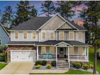 Charming two-story home with a welcoming front porch and well-manicured landscaping at 152 Education Dr, Spring Lake, NC 28390