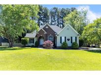 Charming brick home on a well-manicured lawn with mature trees and tasteful landscaping at 186 Stone Cross Dr, Spring Lake, NC 28390