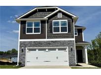 Charming two-story home featuring stone accents, a white garage door, and a beautifully maintained lawn at 211 Drayton Hall Ln, Sanford, NC 27330