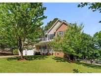 Charming two-story home with brick and vinyl siding, a well-manicured lawn, and mature trees at 227 Carolina Way, Sanford, NC 27332