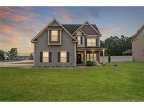 Charming two-story home with manicured lawn and welcoming front porch at 432 Century Dr, Cameron, NC 28326