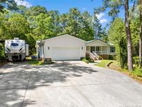 Charming ranch home with a spacious driveway, mature trees, and welcoming front porch at 46 Sherwood Hills Ct, Cameron, NC 28326