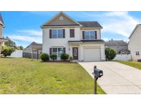 Charming two-story home featuring a manicured lawn, attached garage and driveway at 104 Red Coat Dr, Cameron, NC 28326