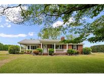 Charming single-story brick home with a welcoming front porch and well-maintained landscaping at 1445 Bethel Baptist Rd, Spring Lake, NC 28390