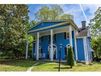 Stately blue home with a large column-lined porch and well-manicured lawn at 236 E Andrews Ave, Henderson, NC 27536