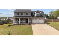 Charming two-story home with a welcoming front porch and a spacious two-car garage, set on a well-manicured lawn at 352 Asheford Way, Cameron, NC 28326