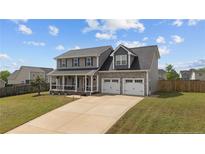 Charming two-story home with a covered front porch and a two-car garage at 352 Asheford Way, Cameron, NC 28326