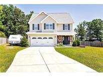 Charming two-story home with a stone-accented entryway, well-manicured lawn and a long driveway at 45 William Bethune Ct, Linden, NC 28356