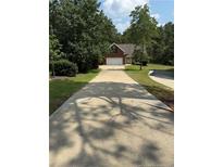 Long driveway leading to brick home with a two-car garage and mature trees at 481 Clearwater Harbour, Sanford, NC 27332