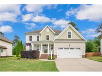 Charming two-story home featuring a manicured front yard and a two-car garage at 112 Saw Grass Ct, Bunnlevel, NC 28323