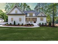 Charming home with a white brick facade, dark wood accents, and a beautifully landscaped front yard at 134 Zion Church Rd, Sanford, NC 27332