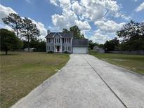 Charming two-story home with grey siding, red shutters, and an attached garage at 23 Glenn Oak Dr, Sanford, NC 27330