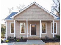 Charming single-story home with a covered front porch, tidy landscaping, and neutral-toned siding at 303 Tanglewood Dr, Louisburg, NC 27549