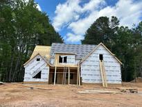 New home under construction showing framing and sheathing, with a ladder against the side and wooded surrounding property at 194 Landon Rdg, Sanford, NC 27330