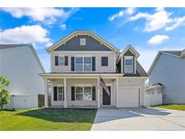 Charming two-story home featuring a covered front porch and attached one-car garage at 21 Bicentennial Way, Cameron, NC 28326