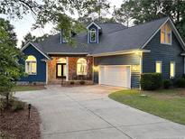 Charming blue home featuring a well-manicured lawn and a spacious driveway leading to an attached garage at 39 Tahoe Cir, Sanford, NC 27332