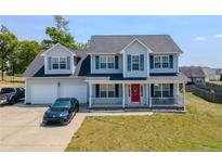 Charming two-story home featuring a welcoming front porch, two-car garage, and well-maintained front yard at 495 Lenoir Dr, Spring Lake, NC 28390