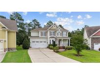 Charming two-story home boasts a well-manicured lawn and a two-car garage at 56 N Skipping Pines Ct, Spring Lake, NC 28390