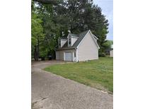 View of the tan siding and green roof of the home's detached garage in a partially wooded lot at 1203 S 3Rd St, Lillington, NC 27546
