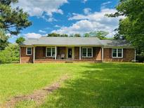Charming brick home with a well-maintained front yard, a covered porch, and inviting curb appeal at 5163 Odell King Rd, Burlington, NC 27217