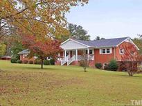 Charming brick home featuring a well-manicured lawn and a welcoming front porch at 104 Beacon Ln, Cameron, NC 28326