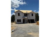 Image of a home under construction, showing the framing and initial stages of development on a sunny day at 110 Blossom Trl, Lillington, NC 27546
