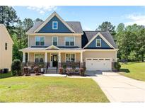 Charming two-story home with a well-manicured lawn and a two-car garage at 170 Valley Stream Rd, Spring Lake, NC 28390