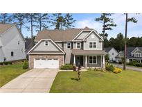 Charming two-story home with stone accents, a well-manicured lawn, and an attached two-car garage at 22 Education Dr, Spring Lake, NC 28390